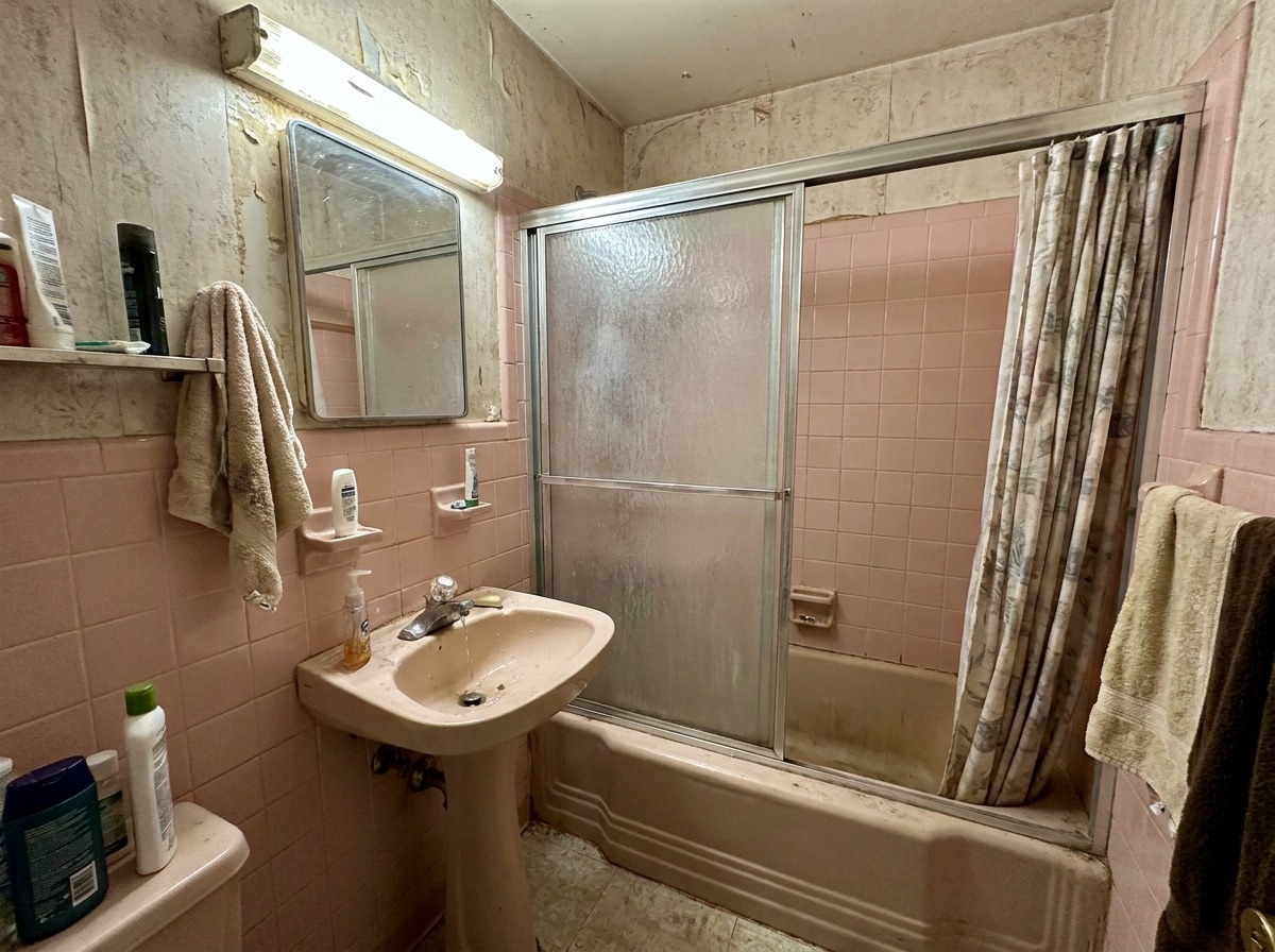 Pink 1960s bathroom with dated tile before remodeling